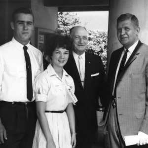 Two 4-H club members standing with L. R. Harrill and unidentified man while attending Club Week at North Carolina State College