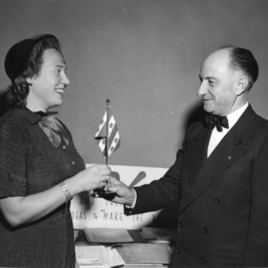 L. R. Harrill handing a flag to a woman