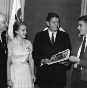 Two 4-H club members standing with L. R. Harrill and an unidentified man