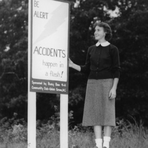 4-H club girl standing next to an automotive safety sign placed by the Busy Bee 4-H Community Club in Union Grove, North Carolina