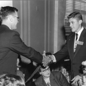 4-H club member shaking hands with an unidentified man