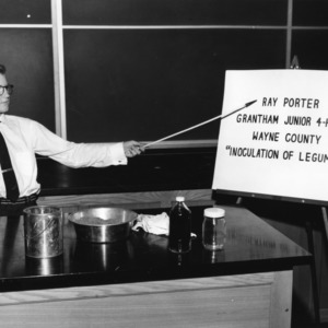 Ray Porter of Wayne County, North Carolina, with exhibit entitled "Inoculation of Legumes," during North Carolina State 4-H Club demonstration competition, 1955
