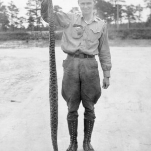 Man holding dead snake