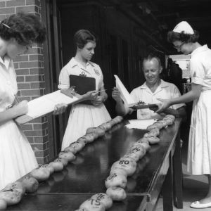 4-H club members judging potatoes during North Carolina State 4-H Club Week, July 1958