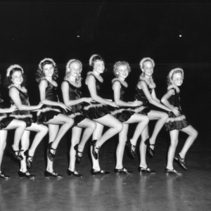Eight 4-H club girls pose in their tap dance costumes for a performance at North Carolina State 4-H Club Week at North Carolina State College in Raleigh