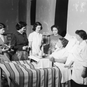 4-H club members gathering around a woman laying in bed as part of a 4-H personal development program