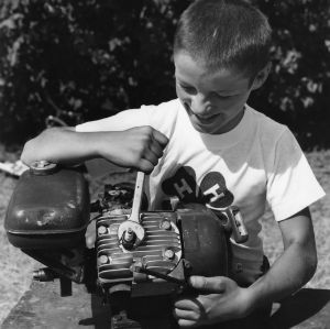 Twelve-year-old boys find it fun to work on small gasoline engines. 4-H Club member Jimmy O'Brien of Wheatland, Wyoming, puts his weight behind the wrench as he removes a spark plug from a 4-cycle engine