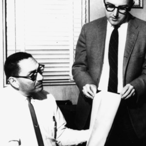 Hank Rutherford and W. K. Walsh looking at fabric