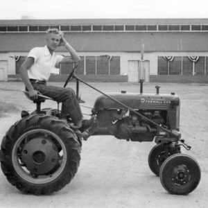 4-H club member sitting on a tractor at a tractor contest, September 23, 1953