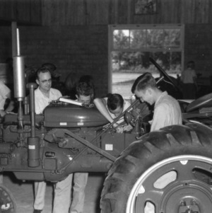 4-H club members working on the inside of a tractor at a 4-H tractor program