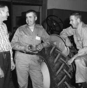 Three 4-H instructors talk next to a tractor at a 4-H tractor program. Man on the far right is Richard Freeman, a Guilford County 4-H leader