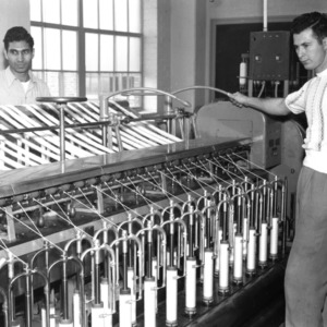 Two men using textile machinery