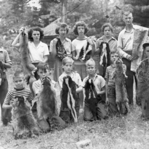 Charles W. Ziegler and 4-H club members posing with animal pelts at Millstone 4-H Camp, 1946