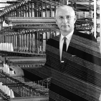 Dean David Chaney posing with a textile machine
