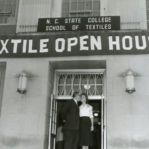 Placement Director of the College of Textiles George Dunlop and Textiles Librarian Georgia Rodetter under a banner reading "Textile Open House" outside Nelson Hall