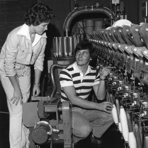 Two students discussing textile machinery