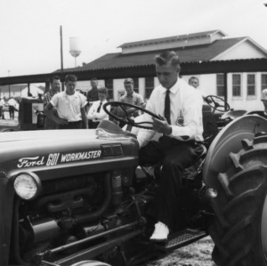 Barry Sigmon of Catawba County, North Carolina, sitting on a Ford 601 Workmaster tractor at the 4-H Southwest District Demonstration day, 1960