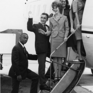 Group of two men and three women boarding an airplane