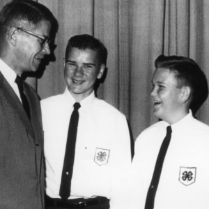 Two 4-H club boys laughing with older man, during North Carolina State 4-H Club Week