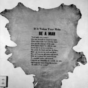 Poem reading "If It Takes Your Hide, Be A Man" hanging in L. R. Harrill's office
