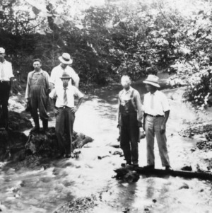 Farmers crossing a creek on a log to visit a demonstration, May 9, 1932