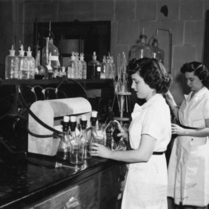 Two unidentified women working in a tobacco lab