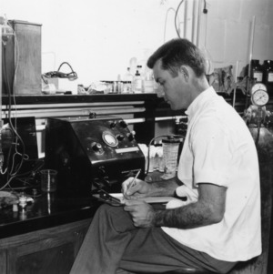 Unidentified man in a laboratory making notes
