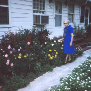 Mrs. Lorraine Phifer in front of her flower beds
