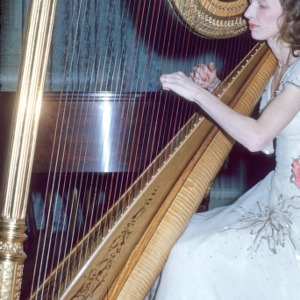Woman playing a harp at a party