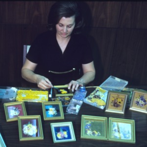 Woman participating in an arts and crafts fair (framed floral patterns)