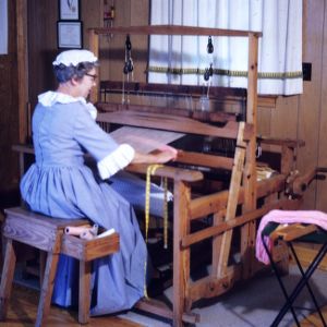 Woman seated at a loom