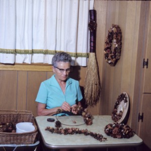 Woman making a wreath from pine cones