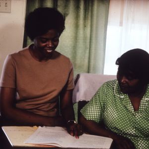 Two African-American women review written materials