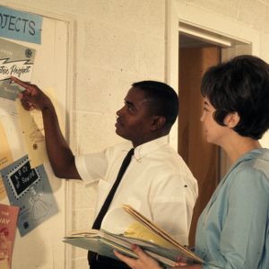 Home Demonstration co-workers review a bulletin board