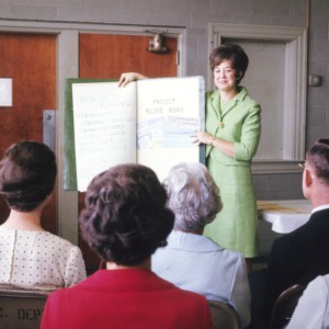 Woman presents to a group on "project record books"