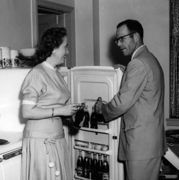 Couple getting Coca-Colas from refrigerator