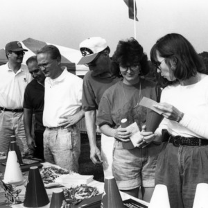 Viewing fan merchandise at a NC State Alumni Association tailgate event, 1990s