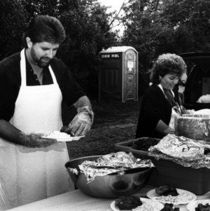 Volunteers prepare food at a NC State Alumni Association tailgate event, 1990s