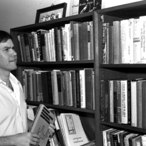 Dr S.T. Alexander beside bookshelf