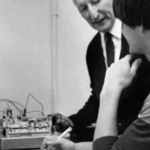 Two men studying electrical equipment