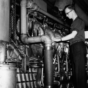 Mechanical Engineering student with diesel engine at the 1956 Engineering Fair