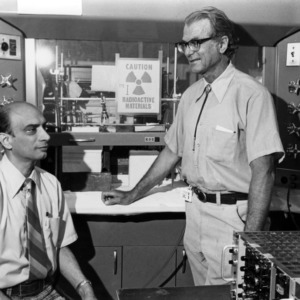 Dr. J. F. Mirza and Dr. L. R. Zunnwaeb in the Nuclear Engineering laboratory where they collect measurements of iodine transport in concrete