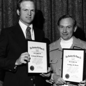 Dr. Ronald W. Roussran and Dr. Wayne M. Brooks with awards