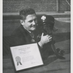 ASPCA photograph: Fireman Kenneth C. Scott poses with dog and ASPCA Certificate of Merit