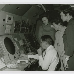 Photograph of Katharine Stinson and others at control panel