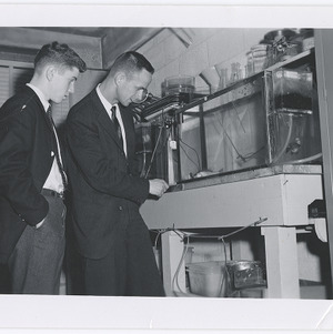 Douglas Mattox and man looking at fish, January 1963