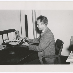 John Mattox at desk with camera