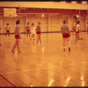People playing volleyball in gym, circa November 1972
