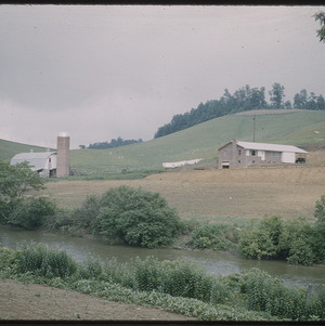 Farmhouse, barn, and silo in field, circa July 1961
