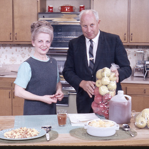 Man and woman posing in kitchen with apples, circa October 1968
